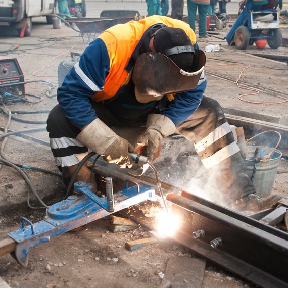 Person beim Schweißen auf einer Baustelle Person beim Schweißen auf einer Baustelle