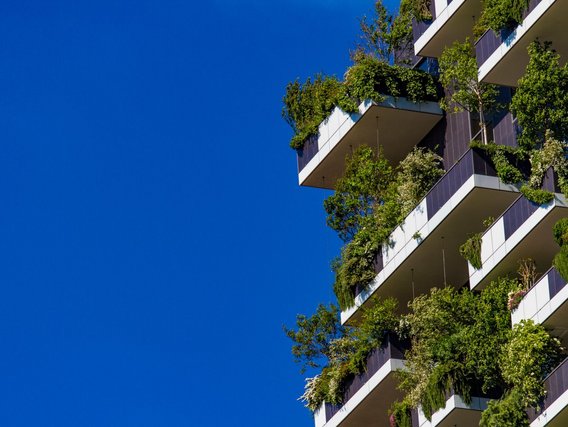 Ein nachhaltiges Gebäude mit grünen Pflanzen auf den Balkonen Ein nachhaltiges Gebäude mit grünen Pflanzen auf den Balkonen