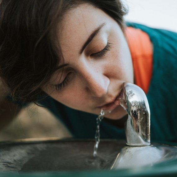 TUEV_NORD_Trinkwasserhygiene Frau trinkt aus einem Trinkwasserspender