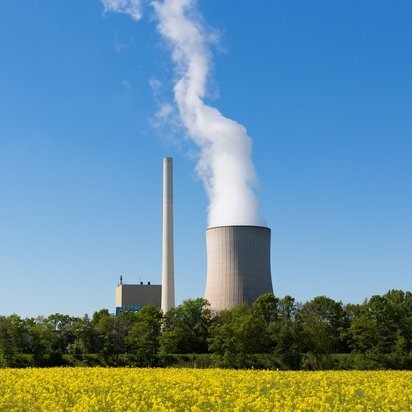 Dampfausstoß aus Kühlturm eines Kraftwerks bei blauem Himmel. Dampfausstoß aus Kühlturm eines Kraftwerks bei blauem Himmel.