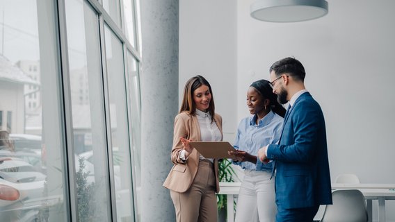 Managementsystemzertifizierung Drei Personen stehen im Raum.
