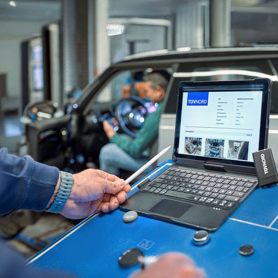 Fahrzeugdiagnose an der TÜV NORD Station Mitarbeiter bei der Fahrzeugdiagnose mit Laptop an der TÜV NORD Station