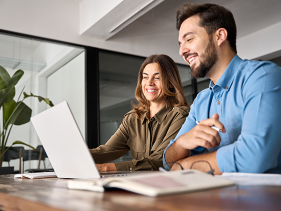 Revision ISO 9001 Zwei Mitarbeiten schauen sich Änderungen im Laptop an