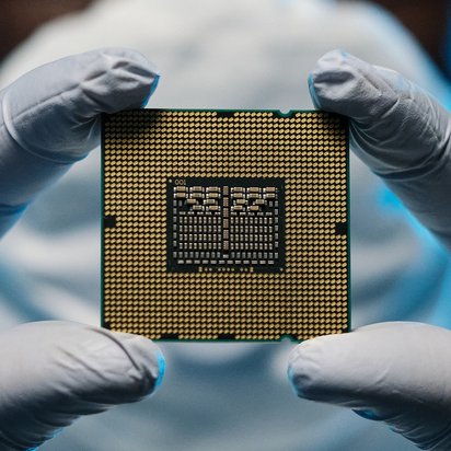 Großaufnahme eines Halbleiters Großaufnahme eines Halbleiters, den eine Person mit Handschuhen zwischen den Zeigefingern und Daumen hält.