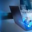 Person arbeitet an Laptop, umgeben von schwebenden digitalen Symbolen für Dokumente und Ordner.