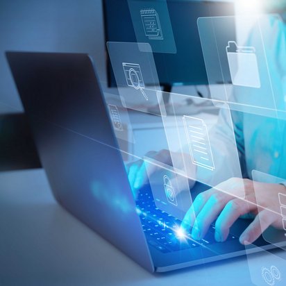 Person arbeitet an Laptop, umgeben von schwebenden digitalen Symbolen für Dokumente und Ordner.