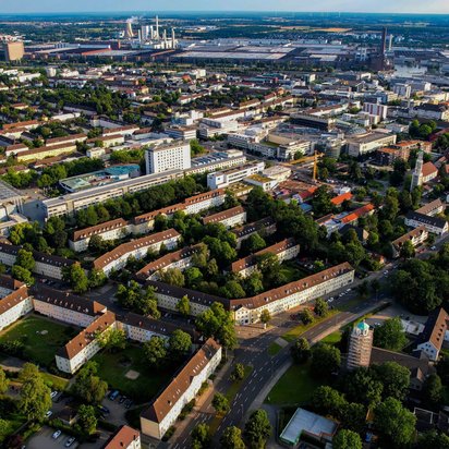 Standorte der TÜV NORD Akademie in Deutschland Luftaufnahme eines Stadtgebiets mit Industrie- und Wohnbebauung im Hintergrund
