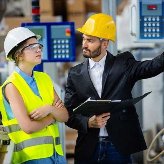 Ingenieurin und Ingenieur in einer industriellen Umgebung Ingenieurin und Ingenieur in einer industriellen Umgebung