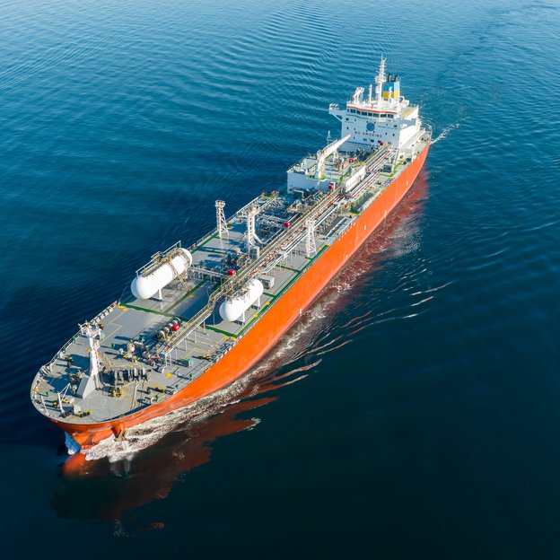 Frachtschiff auf offener See Ein großes Frachtschiff fährt über ruhiges, tiefblaues Wasser.