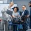 Gruppe von Ingenieuren diskutiert über ein Automobilteil in einem technischen Labor.