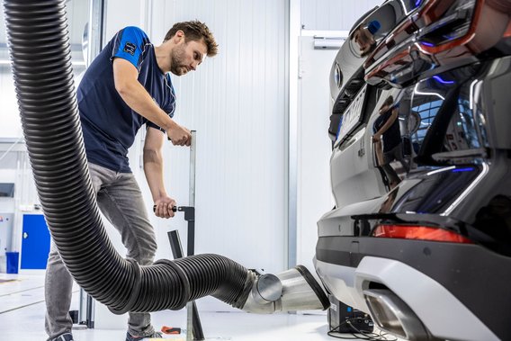 Abgasuntersuchung an der TÜV NORD Station Prüfingenieur bei der Abgasuntersuchung eines Fahrzeugs an der TÜV NORD Station