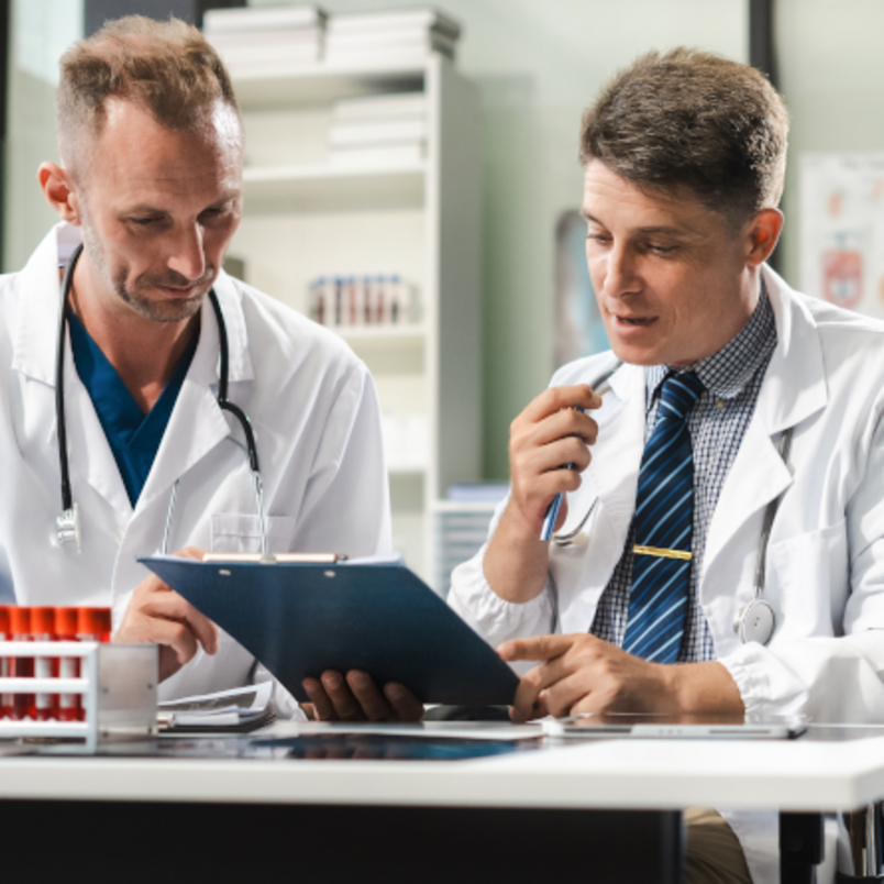 A medical team works together using a tablet and a laptop for research purposes. A medical team works together using a tablet and a laptop for research purposes.