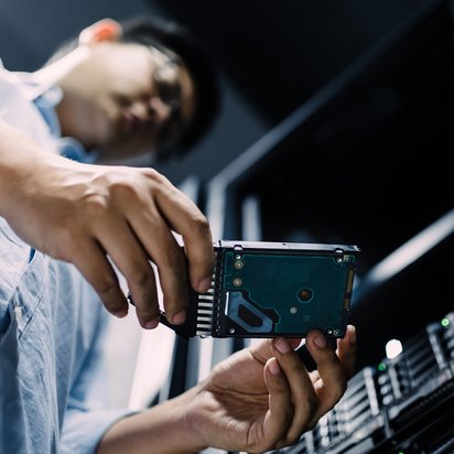 Mann mit Festplatte Ein Mann hält eine Festplatte in den Händen.