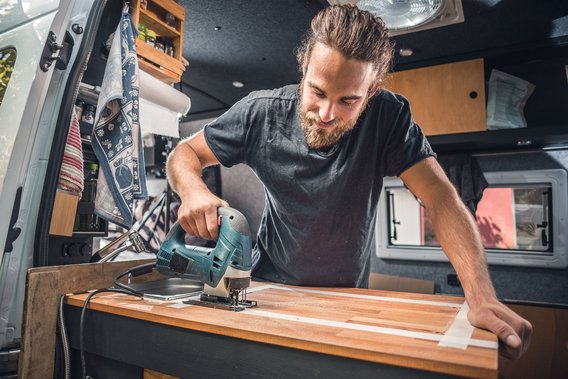 Handwerk im Wohnmobil für individuelle Anpassungen Handwerker bei der Arbeit in einem Wohnmobil