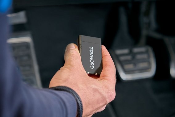TÜV NORD Guardian Prüfingenieur hält TÜV NORD Onboard Diagnose im Fahrzeug
