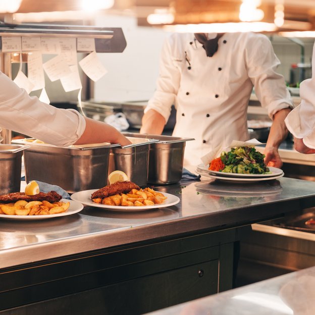 Köche einer Restaurantküche präparieren Mahlzeiten