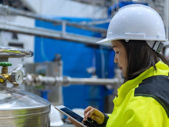 Eine Ingenieurin überprüft einen Wasserstoff-Ventilregler in einer Produktionshalle Eine Ingenieurin überprüft einen Wasserstoff-Ventilregler in einer Produktionshalle