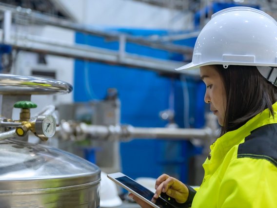 An engineer is working in the production hall and inspecting a valve regulator An engineer is working in the production hall and inspecting a valve regulator