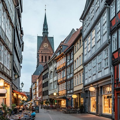 TÜV NORD Standort Hannover für Weiterbildung und Beratung Straßenansicht von Hannover mit Fachwerkhäusern und der Stadtkirche im Hintergrund