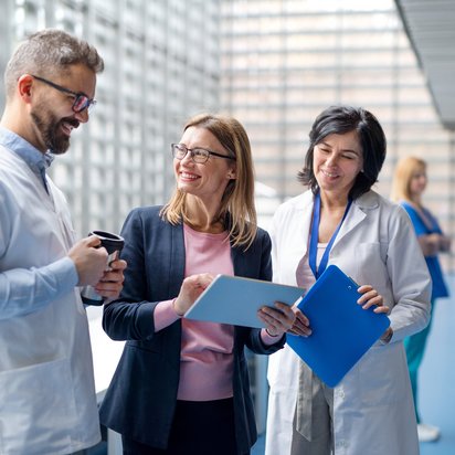 Zertifiziertes Qualitätsfachpersonal ISO 13485 Eine Auditorin unterhält sich mit Medizinern in einer Klinik