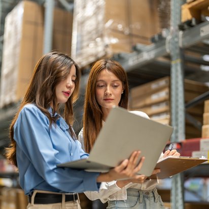 Two women are assessing compliance with social responsibility standards when ordering products from their supply chain. Two women are assessing compliance with social responsibility standards when ordering products from their supply chain.