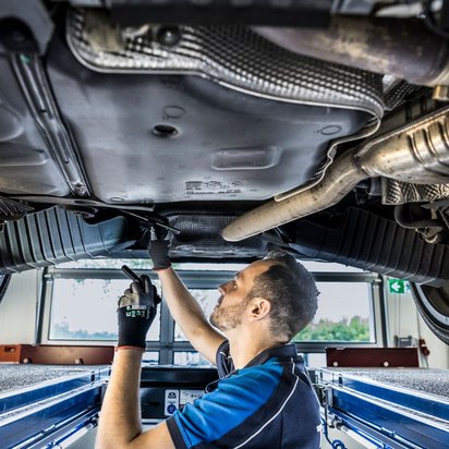 Unterbodeninspektion an der TÜV NORD Station Prüfingenieur bei der Unterbodeninspektion eines Fahrzeugs an der TÜV NORD Station