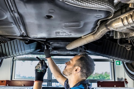 Unterbodeninspektion an der TÜV NORD Station Prüfingenieur bei der Unterbodeninspektion eines Fahrzeugs an der TÜV NORD Station