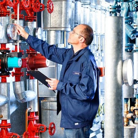 TUEV_NORD_Energiemanagementsystem TÜV NORD Experte überprüft Messgeräte und Ventile in einer Industrieanlage.