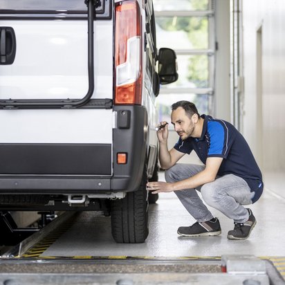 Reifeninspektion eines Wohnmobils an der TÜV NORD Station Prüfingenieur inspiziert die Reifen eines Wohnmobils an einer TÜV NORD Station