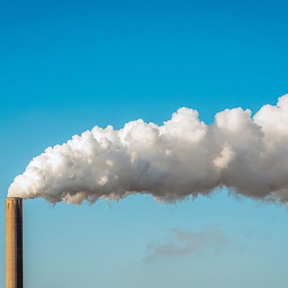 Rauch und Dampf steigen aus einem Fabrikschornstein auf Rauch und Dampf steigen aus einem Fabrikschornstein auf