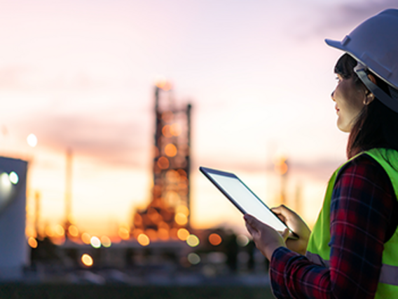 Symbolbild zum Gesetz zur Finanzierung der Energiewende im Stromsektor Mitarbeiter in Schutzkleidung vor Industrieanlage bei Dämmerung - Symbolbild zum Gesetz zur Finanzierung der Energiewende im Stromsektor