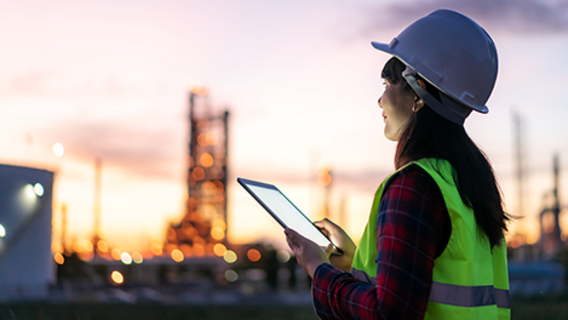 Symbolbild zum Gesetz zur Finanzierung der Energiewende im Stromsektor Mitarbeiter in Schutzkleidung vor Industrieanlage bei Dämmerung - Symbolbild zum Gesetz zur Finanzierung der Energiewende im Stromsektor