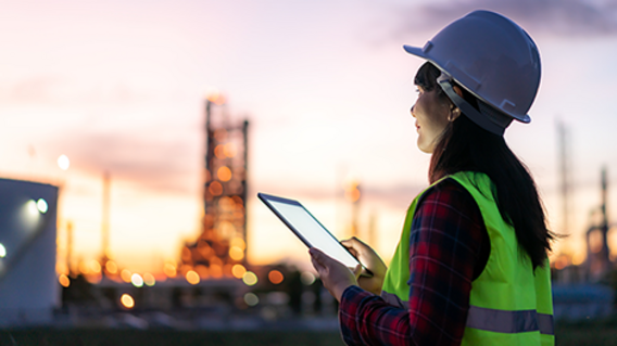 Symbolbild zum Gesetz zur Finanzierung der Energiewende im Stromsektor Mitarbeiter in Schutzkleidung vor Industrieanlage bei Dämmerung - Symbolbild zum Gesetz zur Finanzierung der Energiewende im Stromsektor
