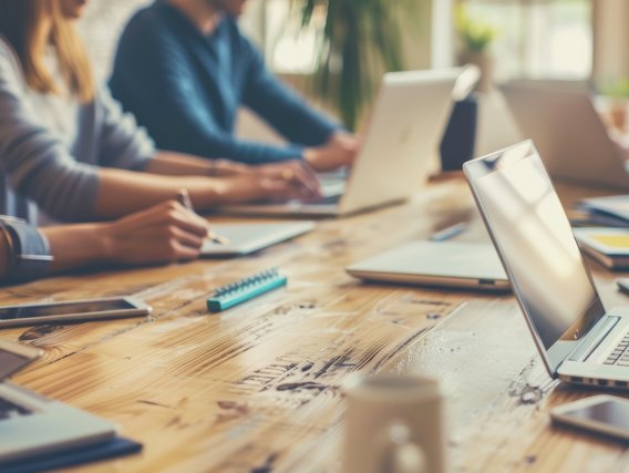 Praxisorientierte Schulung zu Energiesystemen Teilnehmende arbeiten in einer Schulungssituation mit Laptops und Unterlagen – Fokus auf Energie- und Klimathemen