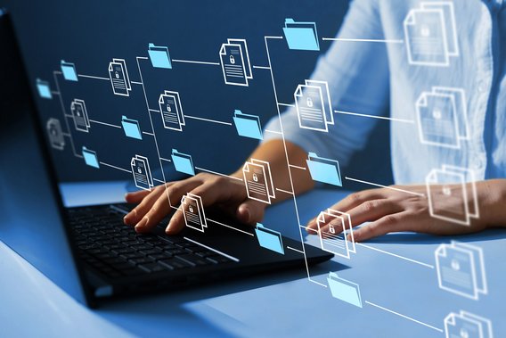 Hände tippen auf einer Laptop-Tastatur, umgeben von schwebenden digitalen Ordner- und Dokumentensymbolen.