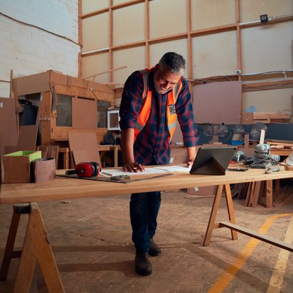 Ein Mann in Schutzkleidung stützt sich auf einen Tisch und prüft Unterlagen zur Bauproduktenverordnung. Ein Mann in Schutzkleidung stützt sich auf einen Tisch und prüft Unterlagen zur Bauproduktenverordnung.